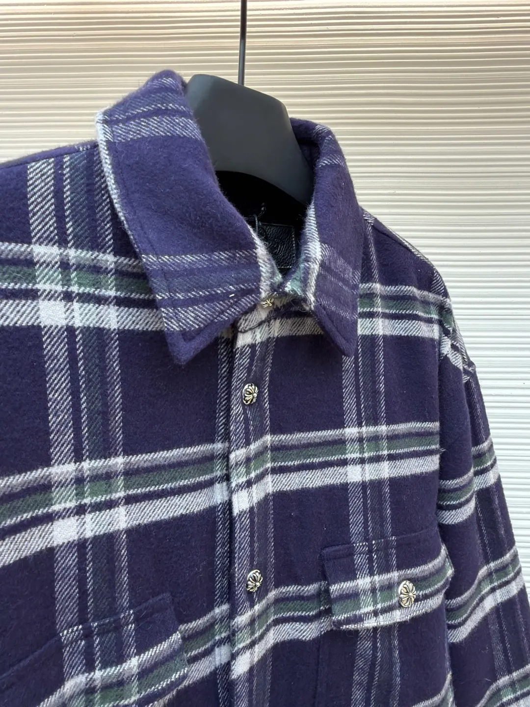 Chrome Hearts Contrast Checkered Lapel Shirt Jacket ●Item No.: 1682307-C05 ●Fabric: Cotton Fabric ●Technology: Made on Positioning Cutting Machine ●Color: Blue and White Plaid ●Version: Fitted ●Weight: Approximately 1030g ●Size: S-M-L-XL ●Description: This Louis Vuitton plaid shirt-style jacket is made of high-count wool blended brushed fabric imported from Italy. It is woven into a classic blue, white and green plaid pattern through yarn-dyed jacquard technology. The yarn is first dyed and then woven to ensure that the plaid color is clear and not easy to fade. The fabric has been pre-shrunk, and the shrinkage rate is controlled within 1%. The body pieces are cut using laser positioning, and the check pattern alignment error does not exceed 0.3cm. The double patch pockets on the front are sewn with welted three-dimensional sewing technology, and the edges of the pockets are padded for a crisper shape. The placket is equipped with custom metal engraved snap buttons, which accurately echo the plaid pattern of the body; the shoulders are made of seamless epaulette splicing technology, and the wiring is smooth and seamless. The double-needle locking technology on the cuffs and hem enhances durability. The overall stitch length is maintained at 7 needles per centimeter, and the wiring is even and smooth. The lining is made of breathable cotton and linen blended materials, taking into account texture and wearing comfort, fully demonstrating the brand's exquisite clothing technology. The overall wiring is straight and delicate, the fabric is comfortable and soft, and the color is consistent without color difference. It can be matched with the same style to create a fashionable look and control various occasions. Customized accessories, complete with three standards, same style for men and women!
